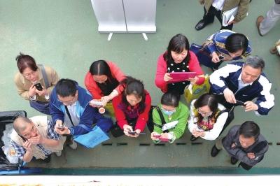 家长在校园开放日拍摄招生资料。京华时报记者徐晓帆摄