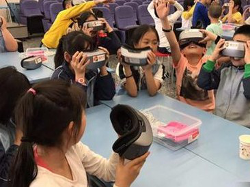 图为北京康乐小学学生体验VR教学。