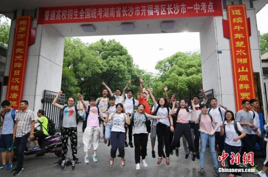 6月8日下午，2017普通高校全国招生统考结束，几位考生走出长沙市一中考点后起跳狂欢。中新社记者 杨华峰 摄