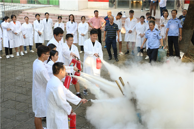 学生在老师的指导下操作灭火器灭火
