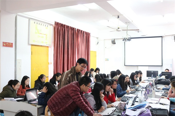 企业资深会计师在指导学生进行电脑做账